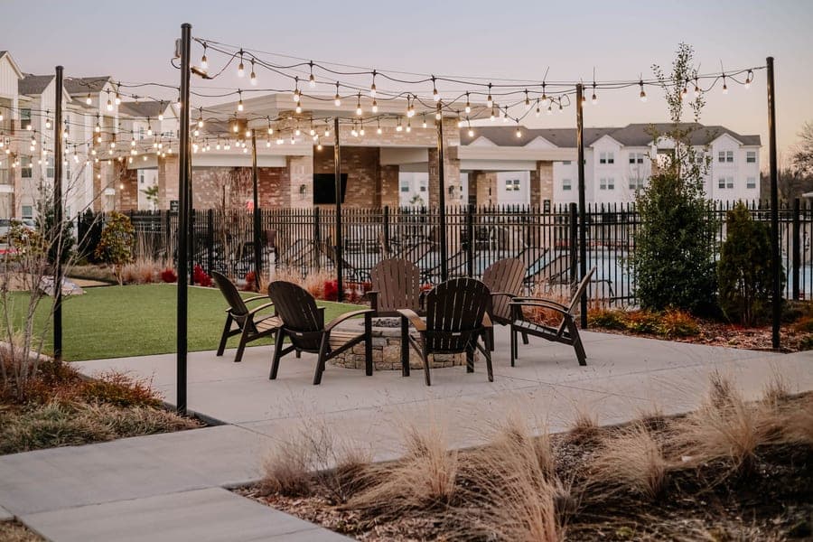 An outdoor patio with chairs and string lights at dusk