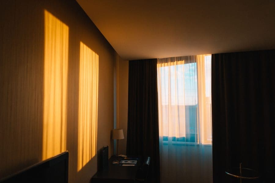 Morning light shining through sheer curtains in a dim room